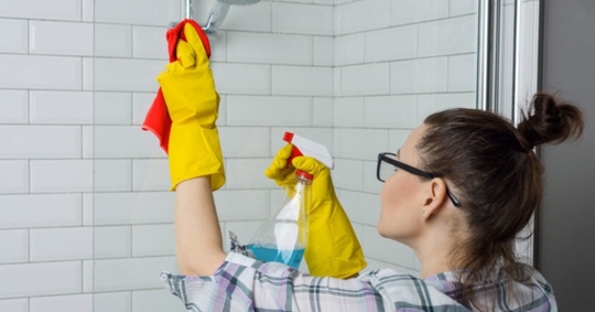 A homeowner cleaning their shower