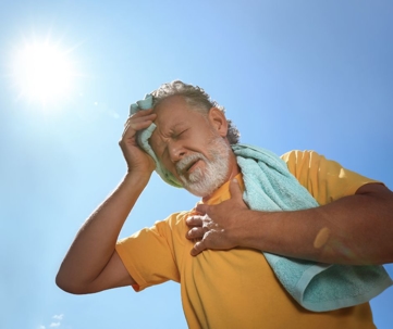 man in hot weather holding chest